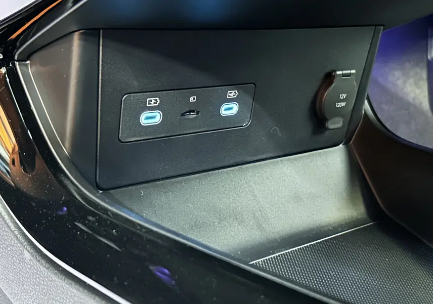 Gros plan sur la console centrale du BYD SEAL U avec deux ports USB-C éclairés en bleu et une prise 12V.