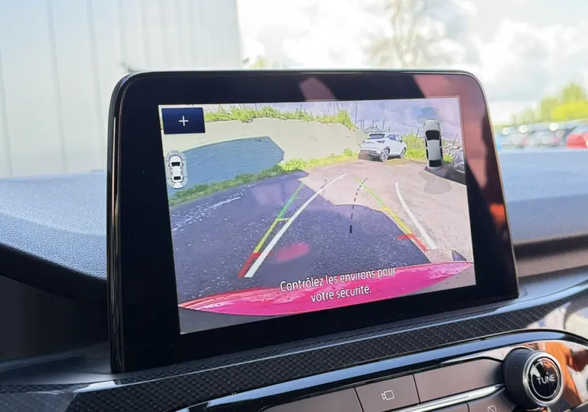 Écran tactile intérieur montrant la caméra de recul avec vue arrière du Ford Kuga rouge Lucifer.