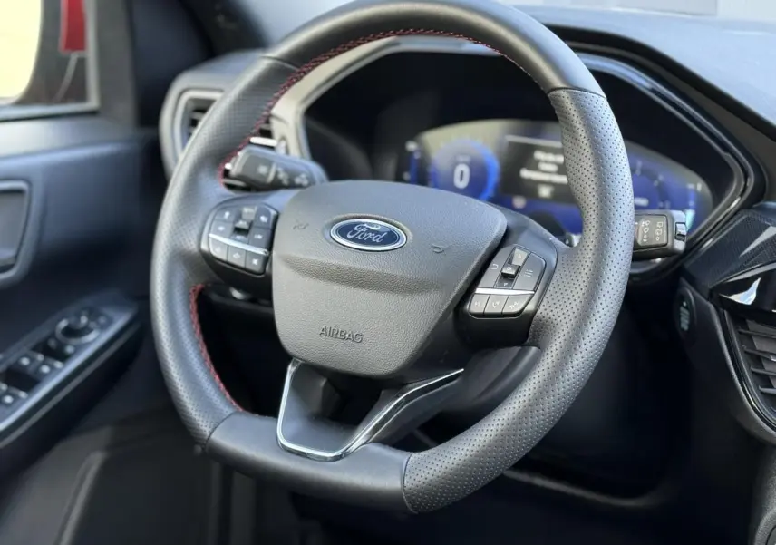 Volant perforé noir avec surpiqûres rouges et tableau de bord numérique du Ford Kuga 2.0 EcoBlue 120 BVA ST-Line.