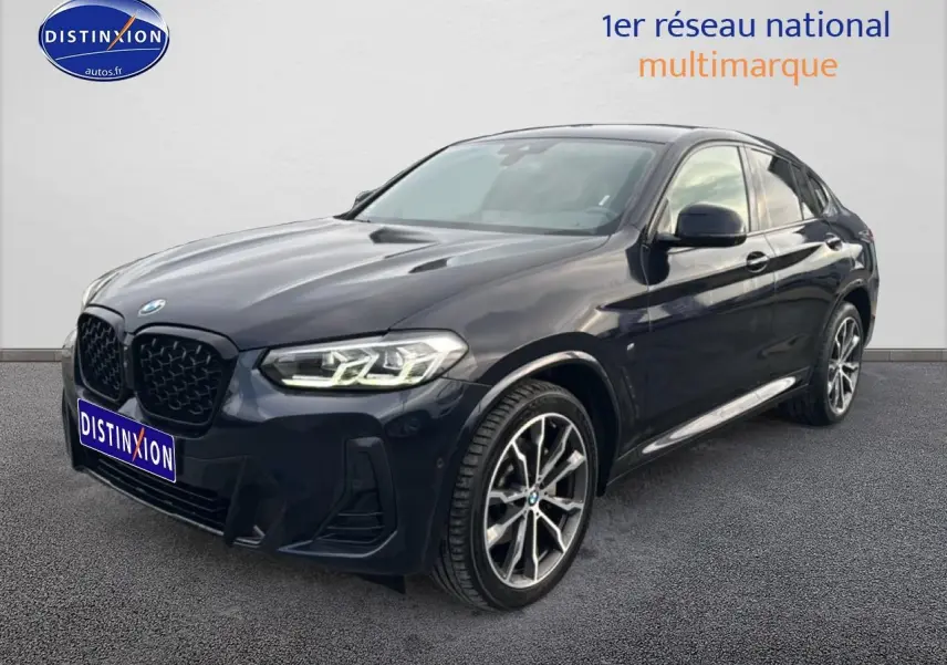 BMW X4 xDrive30d 2022 noir en vue 3/4 avant droit, avec jantes alliage et phares LED allumés.