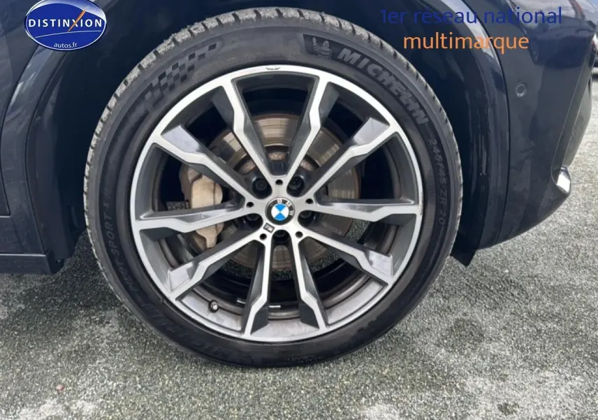 Gros plan sur la jante alu et pneu Michelin du côté avant droit d’un BMW X4 noir (g02) xdrive30d 286 M Sport.