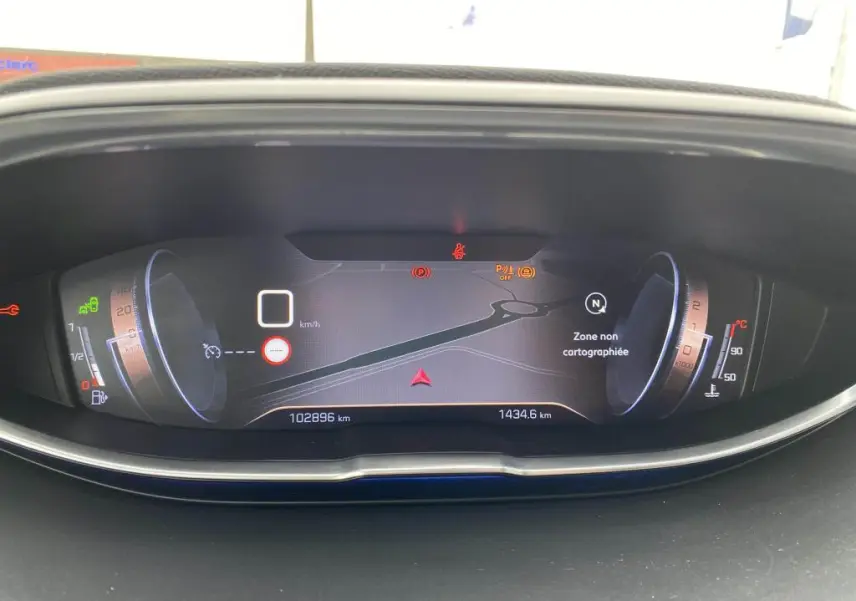 Tableau de bord numérique du Peugeot 3008 blanc, affichant la vitesse à 0 km/h et une carte de navigation en zone non cartographiée.