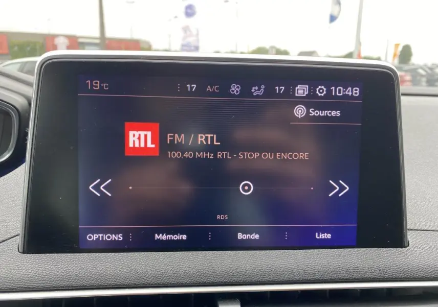 Écran tactile central du tableau de bord du Peugeot 3008 blanc, affichant la radio FM RTL à 10h48.