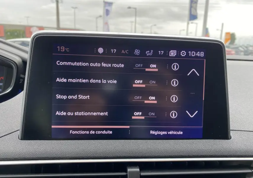 Écran tactile central du Peugeot 3008 blanc 2018 affichant les réglages d’aides à la conduite en intérieur.