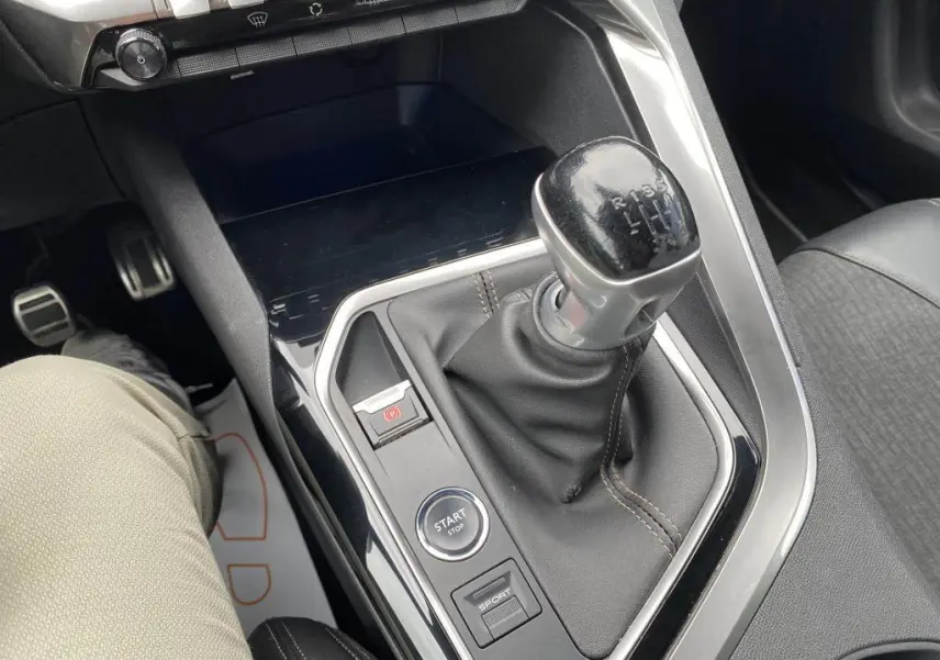 Gros plan sur la console centrale du Peugeot 3008 blanc 2018, mettant en valeur le levier de vitesse manuel et les boutons Start/Stop et Sport.