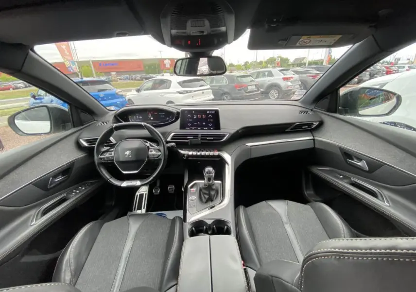 Vue intérieure avant du Peugeot 3008 blanc 2018, avec tableau de bord numérique et levier de vitesse manuel visible.