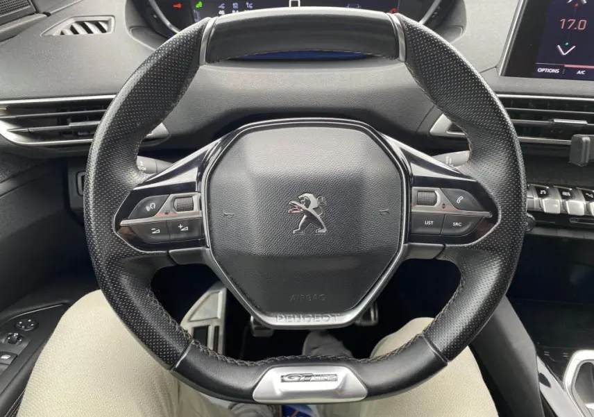 Vue rapprochée du volant cuir noir avec logo Peugeot et badge GT Line du SUV blanc Peugeot 3008 2018.