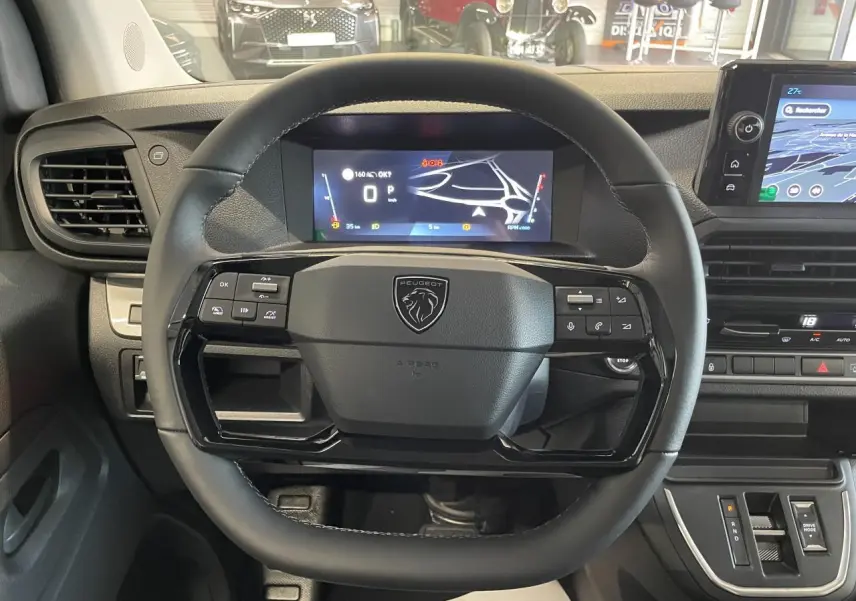 Vue intérieure centrée sur le volant cuir noir et l'écran numérique du tableau de bord du Peugeot Expert Fourgon gris Artense.