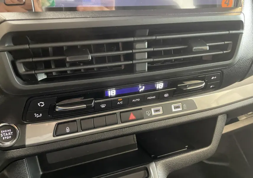 Détail de la console centrale du Peugeot Expert Fourgon gris Artense, montrant les commandes de climatisation et prises USB.