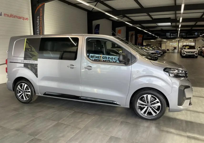 Vue latérale droite du Peugeot Expert Fourgon gris Artense avec décor noir et jantes alliage 17 pouces en showroom.