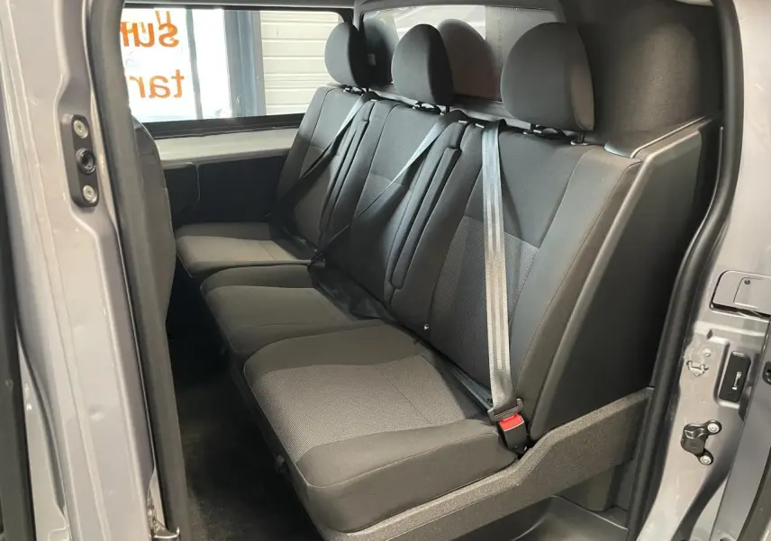 Vue intérieure de la banquette arrière trois places en tissu gris du Peugeot Expert Fourgon gris Artense, côté droit ouvert.