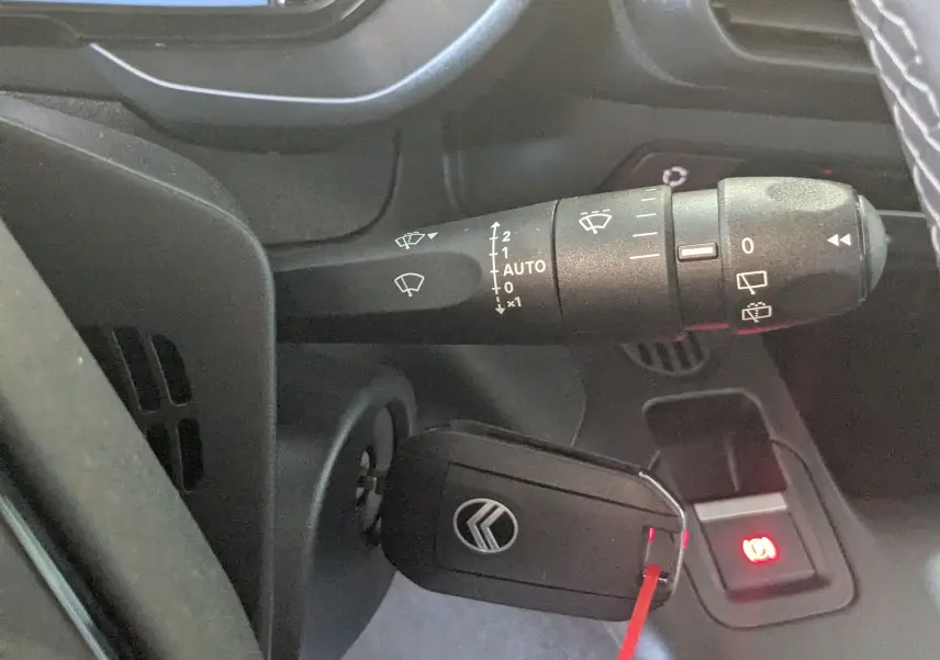 Gros plan intérieur sur la commande d’essuie-glace et la clé de contact du Citroën Berlingo 2026, finition gris artense.