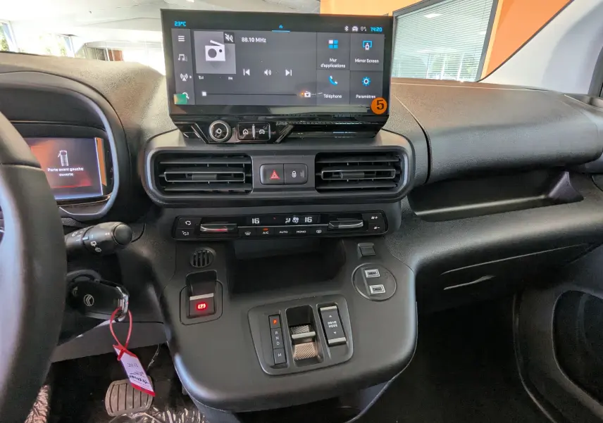 Vue intérieure du tableau de bord du Citroën Berlingo 2026 gris, avec écran tactile central et commandes de climatisation.