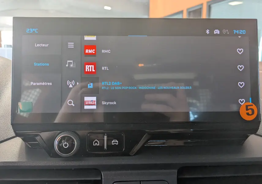 Écran tactile central du Citroën Berlingo 2026 affichant les stations radio, avec commandes sous l'écran en finition noire.