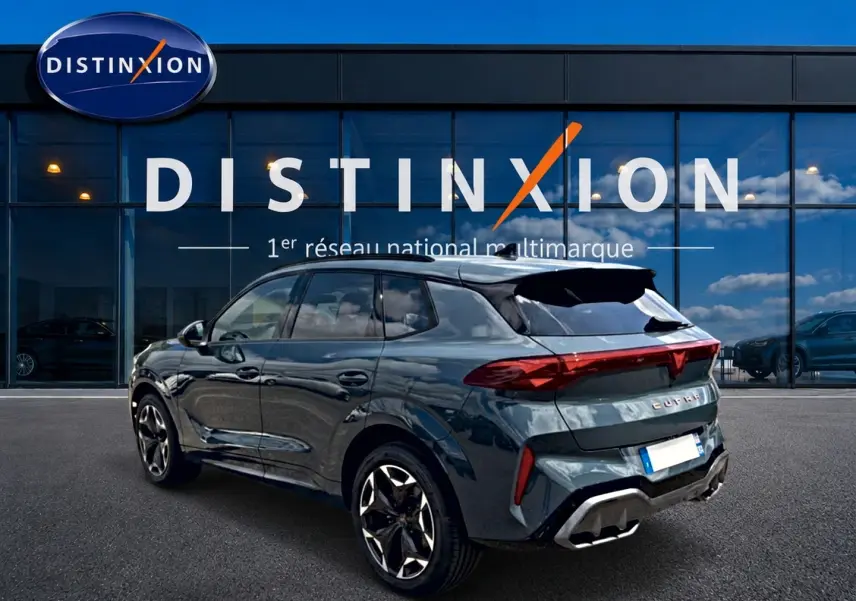 Vue 3/4 arrière droite d'un CUPRA Terramar bleu fjord avec jantes 19 pouces devant une vitrine Distinxion.