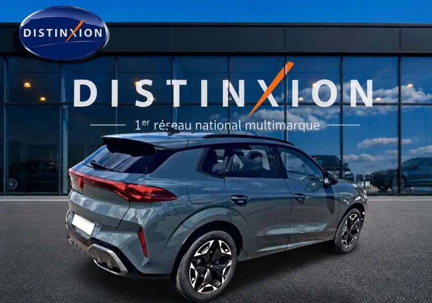 Vue 3/4 arrière droite d'une CUPRA TERRAMAR bleu fjord avec jantes 19 pouces devant une vitrine Distinxion.