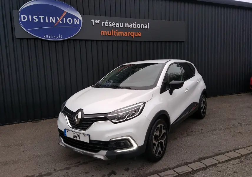 Renault Captur blanc en 3/4 avant droit, avec signature lumineuse LED et jantes alliage noires et argentées.