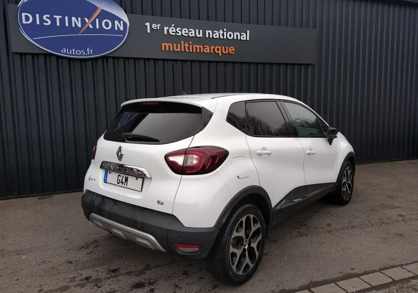 Vue 3/4 arrière droite d'un Renault Captur blanc de 2017 avec vitres teintées et jantes alliage distinctives.