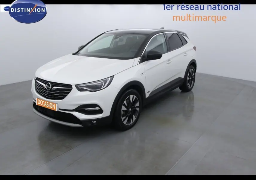 Opel Grandland X blanc nacré vu en 3/4 avant droit avec toit noir et jantes bicolores dans un studio lumineux