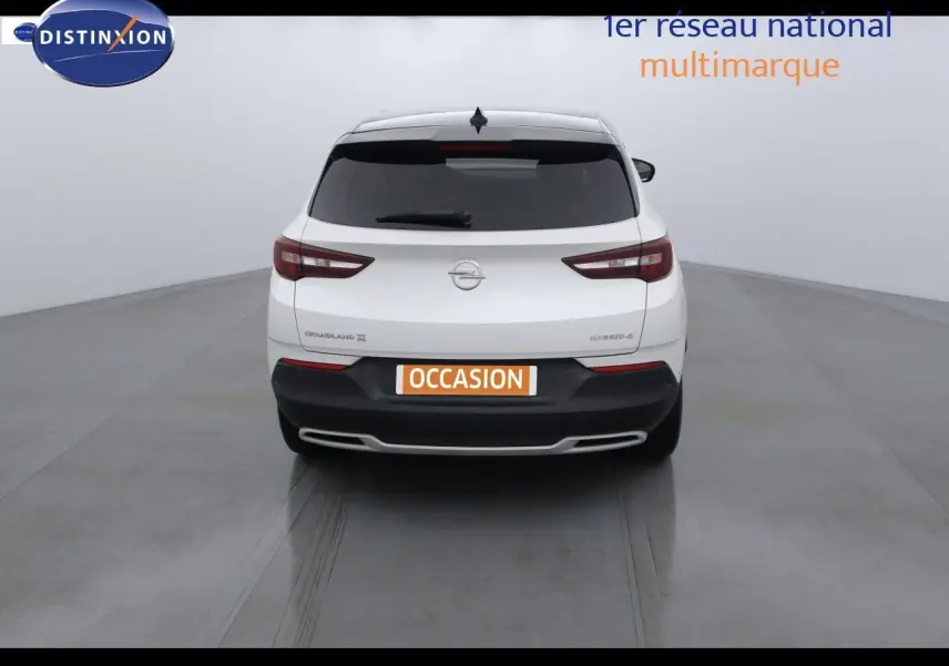 Vue arrière d'un Opel Grandland X blanc nacré hybride rechargeable, avec feux arrière LED et plaque occasion visible.