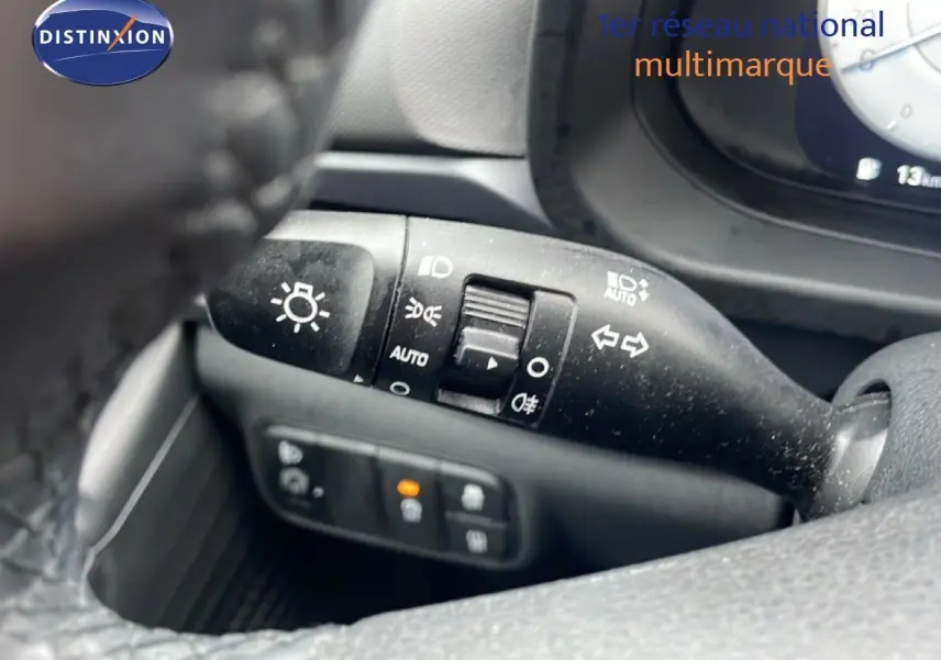 Gros plan sur la commande des feux et clignotants côté gauche du volant d’une Hyundai i20 gris Aurora Metal 2025.