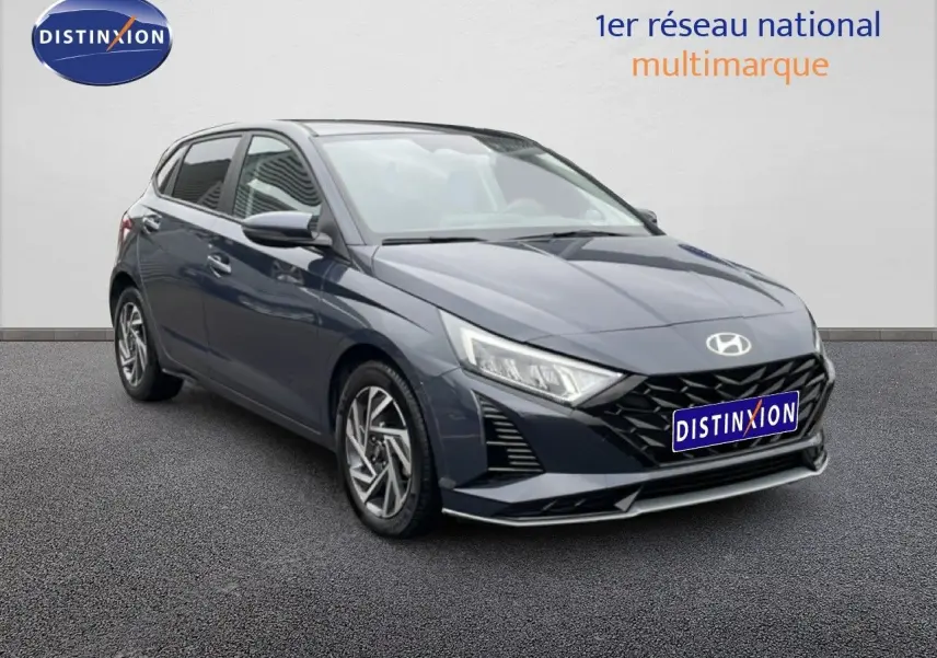 Vue 3/4 avant droit d'une Hyundai i20 2025 gris Aurora Metal avec calandre noire et jantes alliage.