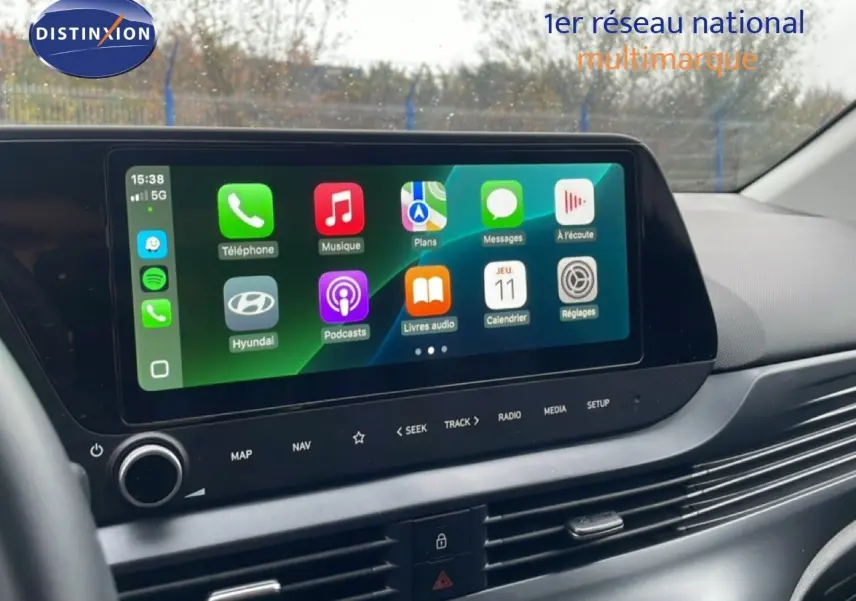 Écran tactile central de la Hyundai i20 2025 affichant les applications Apple CarPlay, vue intérieure côté conducteur.