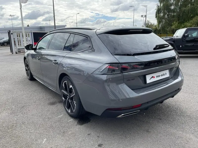 Vue 3/4 arrière droite d'une Peugeot 508 SW gris Selenium avec jantes noires et vitres surteintées.