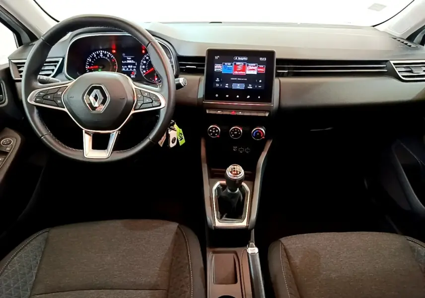 Vue intérieure avant de la Renault Clio Business blanche 2021, volant cuir, écran tactile central et boîte manuelle visible.