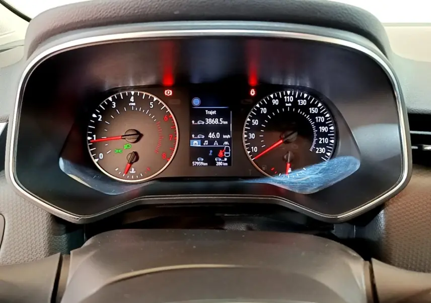 Vue rapprochée du tableau de bord de la Renault Clio Business blanche, affichage numérique et compte-tours analogiques.