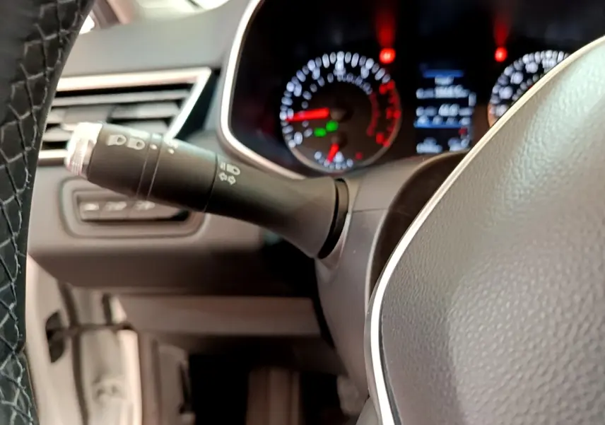 Gros plan sur le volant et le combiné d'instruments éclairé de la Renault Clio Business blanche de 2021.