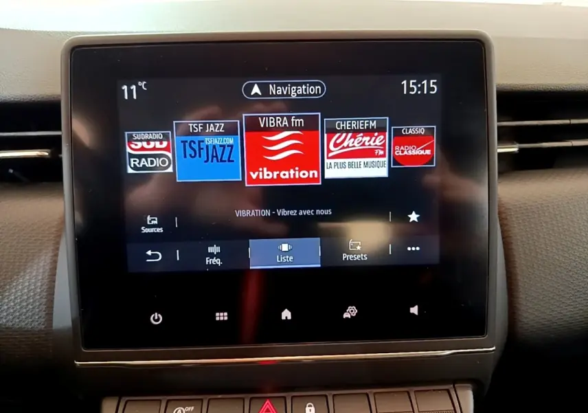 Écran tactile central de la Renault Clio Business blanc, affichant les stations radio avec interface moderne.