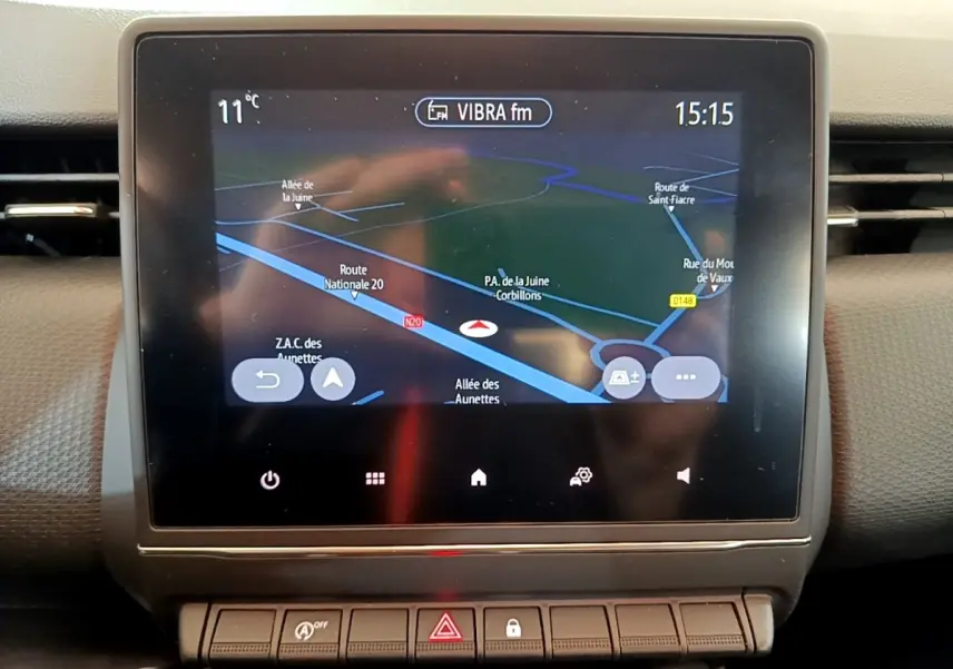 Écran tactile central affichant la navigation 3D dans l’habitacle d’une Renault Clio Business blanche, vue de face.