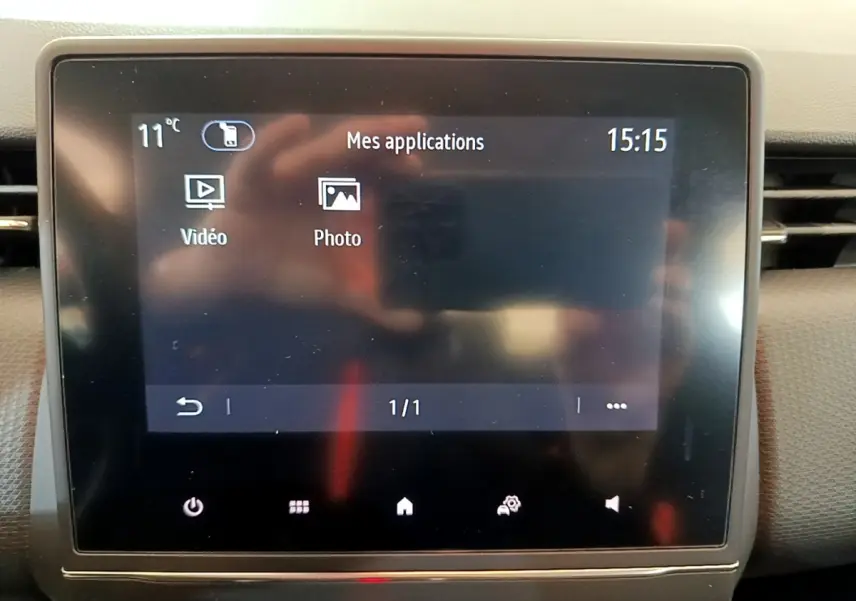 Écran tactile central de la Renault Clio Business blanc, affichant les applications vidéo et photo à 15h15.