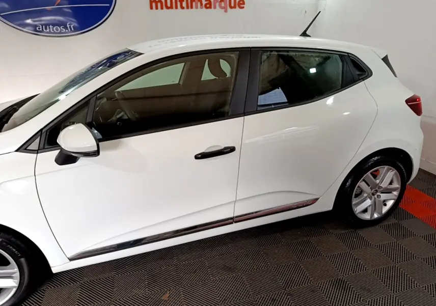 Profil côté gauche de la Renault Clio Business blanche 2021, avec jantes alliage et poignées de porte noires.