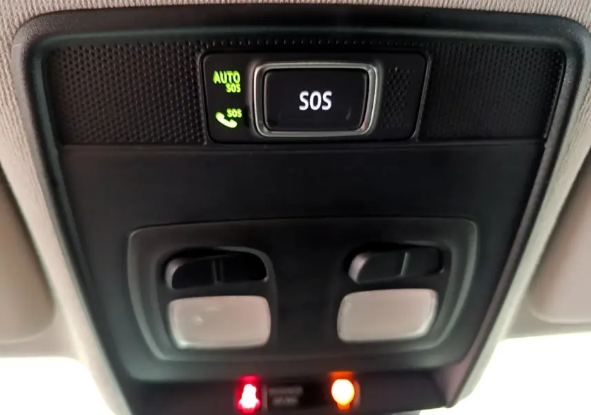 Vue en contre-plongée du plafonnier noir avec bouton SOS éclairé vert dans l'habitacle de la Renault Clio blanche 2021.