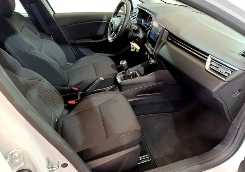 Intérieur de la Renault Clio Business blanc, vue côté conducteur, sièges tissu noir et tableau de bord moderne avec écran tactile.