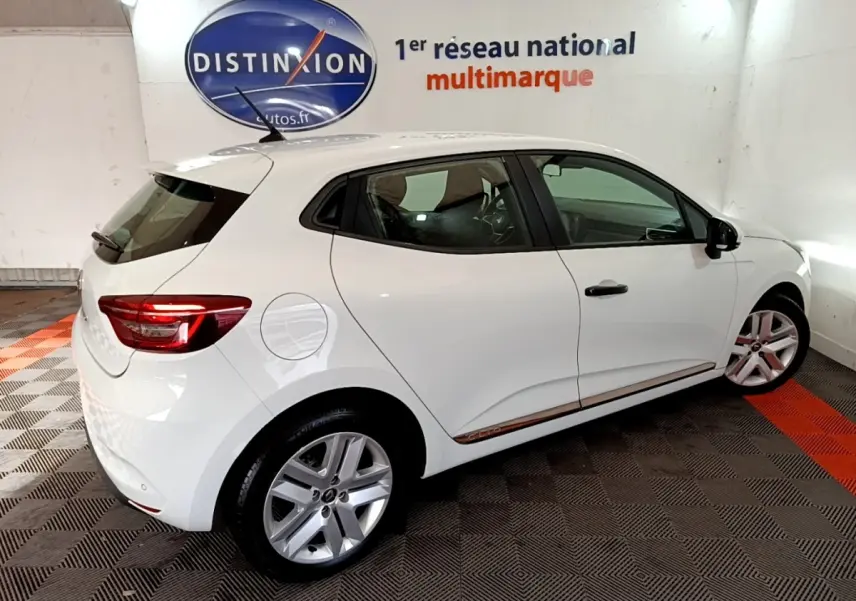 Renault Clio Business blanc vue de profil côté droit, avec jantes alliage et feux arrière allumés.
