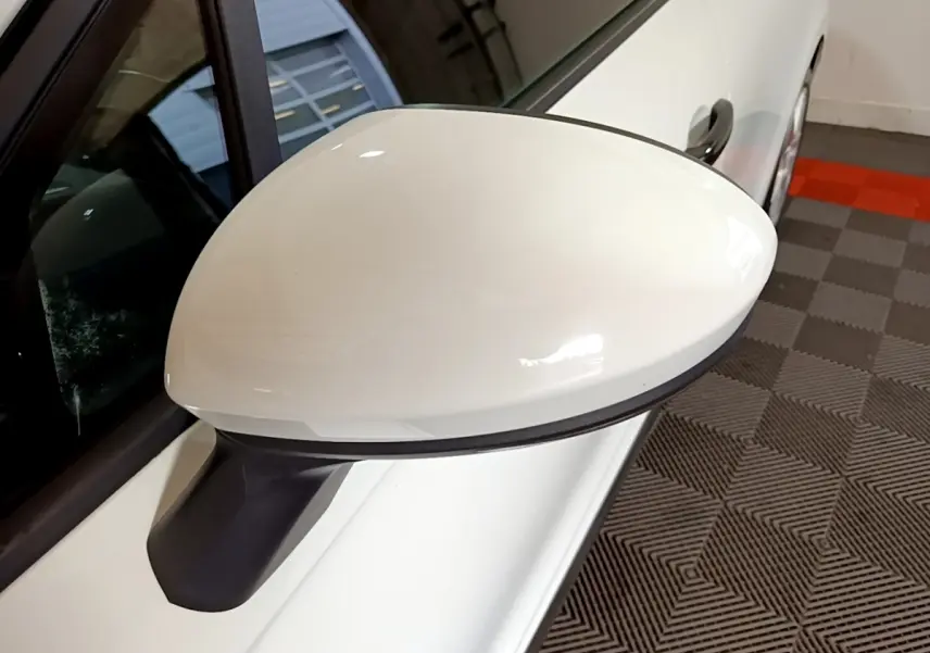 Rétroviseur côté gauche blanc d'une Renault Clio Business 2021, vue rapprochée avec porte et poignée visibles.