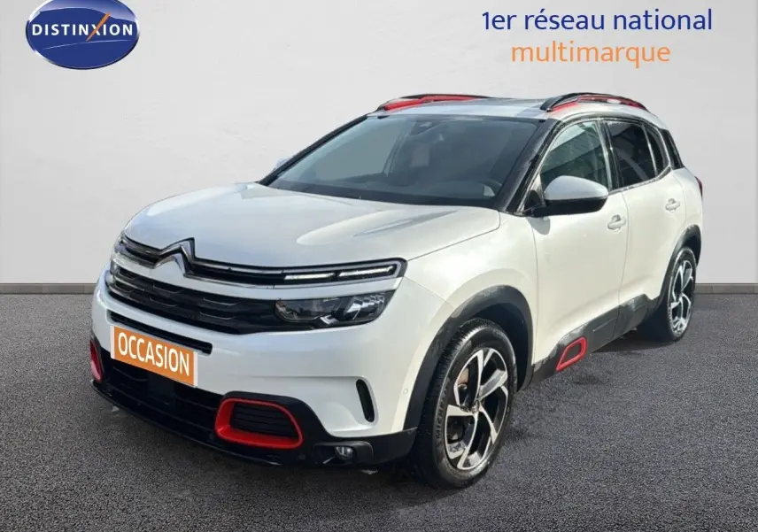 Citroën C5 Aircross blanc nacré, vue 3/4 avant droit avec détails rouges sur boucliers et jantes bicolores.