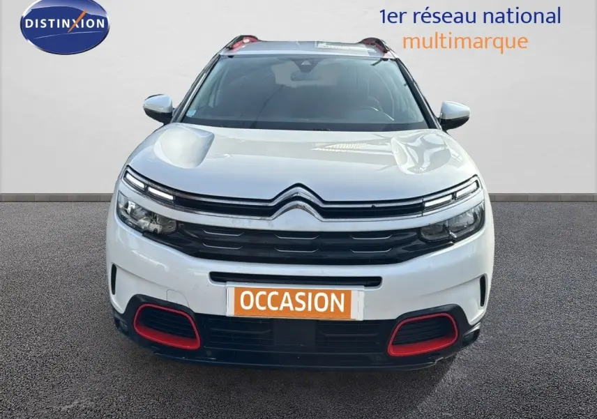Vue de face d'un Citroën C5 Aircross blanc nacré avec détails rouges sur le pare-chocs et calandre noire.