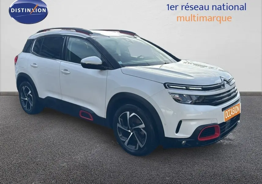 Citroën C5 Aircross blanc nacré en 3/4 avant droit avec jantes bi-ton et inserts rouges distinctifs.