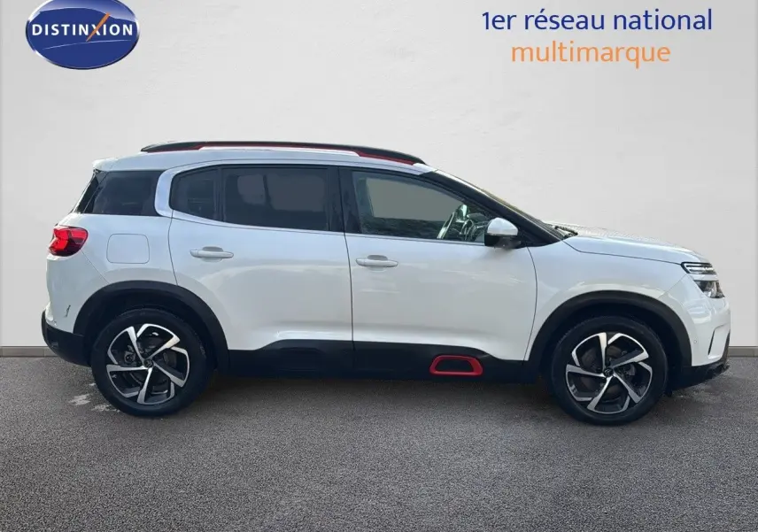 Profil droit d’un Citroën C5 Aircross blanc nacré avec jantes bi-ton et détails rouges sur bas de caisse.