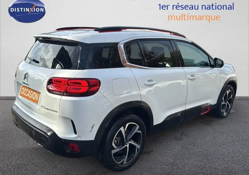 Vue 3/4 arrière droite d’un Citroën C5 Aircross blanc nacré avec jantes bi-ton et toit noir.