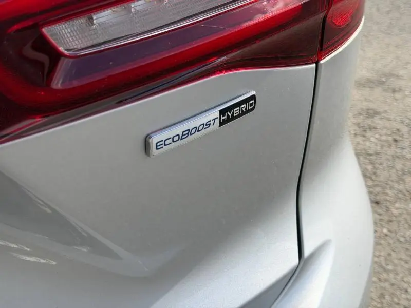 Gros plan sur l'arrière droit gris lunaire métallisé d'une Ford Focus SW 2023 avec badge Ecoboost Hybrid visible.