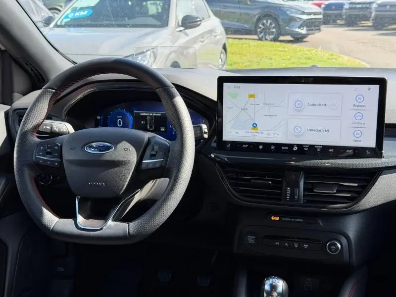 Vue intérieure du tableau de bord et volant de la Ford Focus SW 2023 avec écran tactile et volant multifonction.