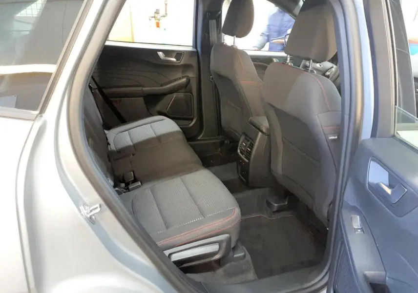 Vue intérieure côté droit des sièges arrière gris foncé avec surpiqûres rouges du Ford Kuga 2024 gris Solar.