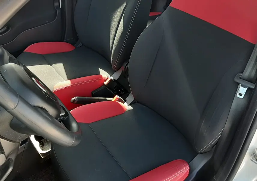 Vue intérieure côté conducteur de la Fiat Panda 1.2 69CH Pop 2018 avec sièges tissu noir et rouge contrasté.