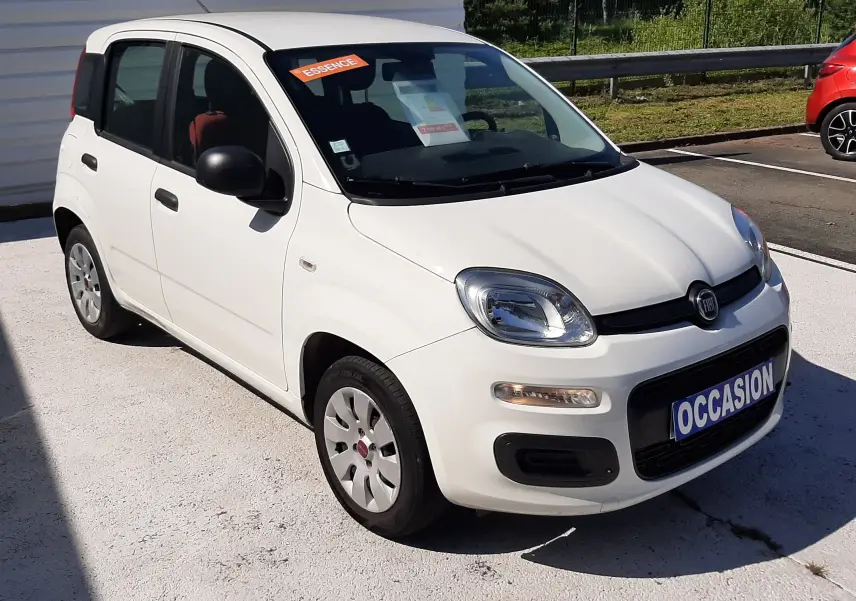 Vue 3/4 avant droite d'une Fiat Panda blanche 2018 essence avec plaque "OCCASION" et intérieur rouge visible.