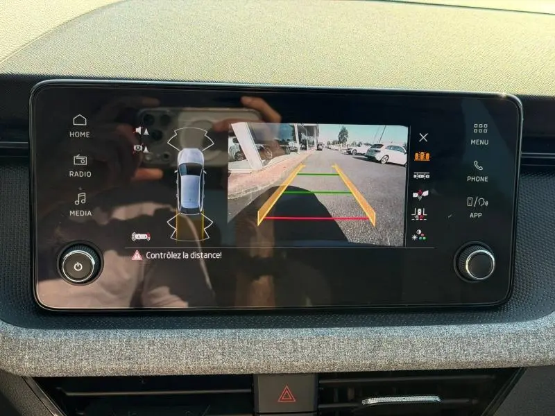 Écran tactile intérieur de la Skoda Scala noir Magic nacré montrant la caméra de recul avec guidage couleur.